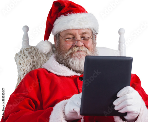 Close-up of Santa Claus holding digital tablet on armchair