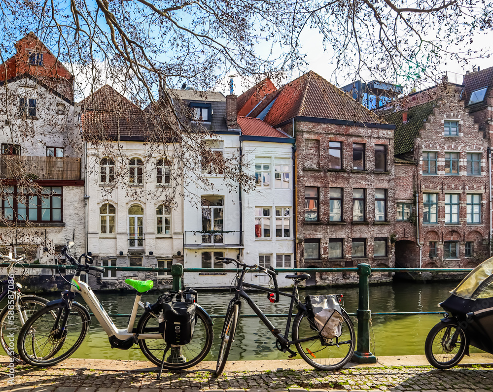 Parked bikes along a canal in the medieval city of Ghent, Belgium. Travel concept