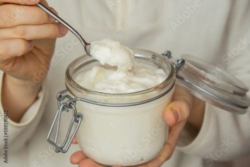Картината върху платно Unrecognizable woman eating from Glass jar natural organic homemade yogurt
