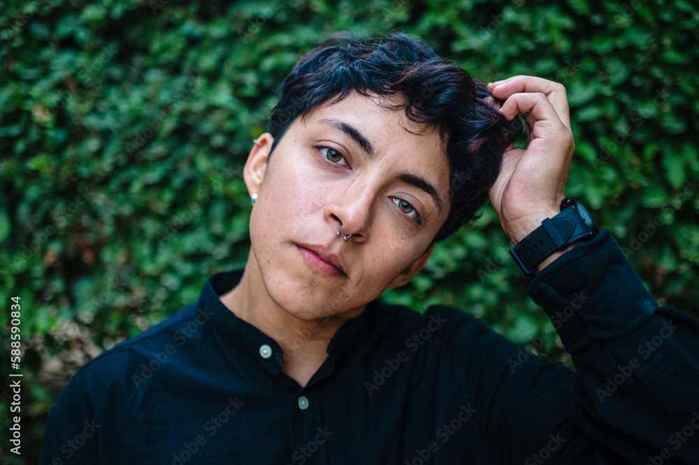 Close-up view of a transgender person posing on natural background. Close-up view of a transgender person posing on natural background.