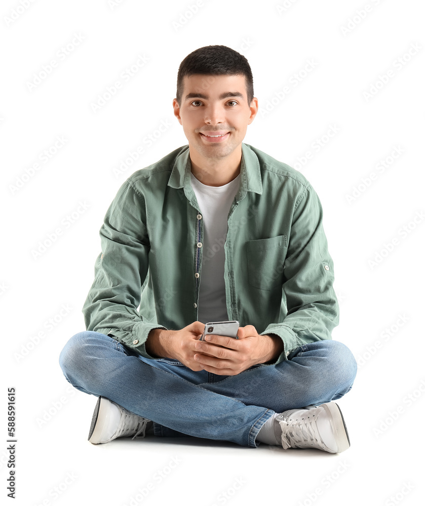 Young guy with mobile phone sitting on white background Young guy with mobile phone sitting on white background