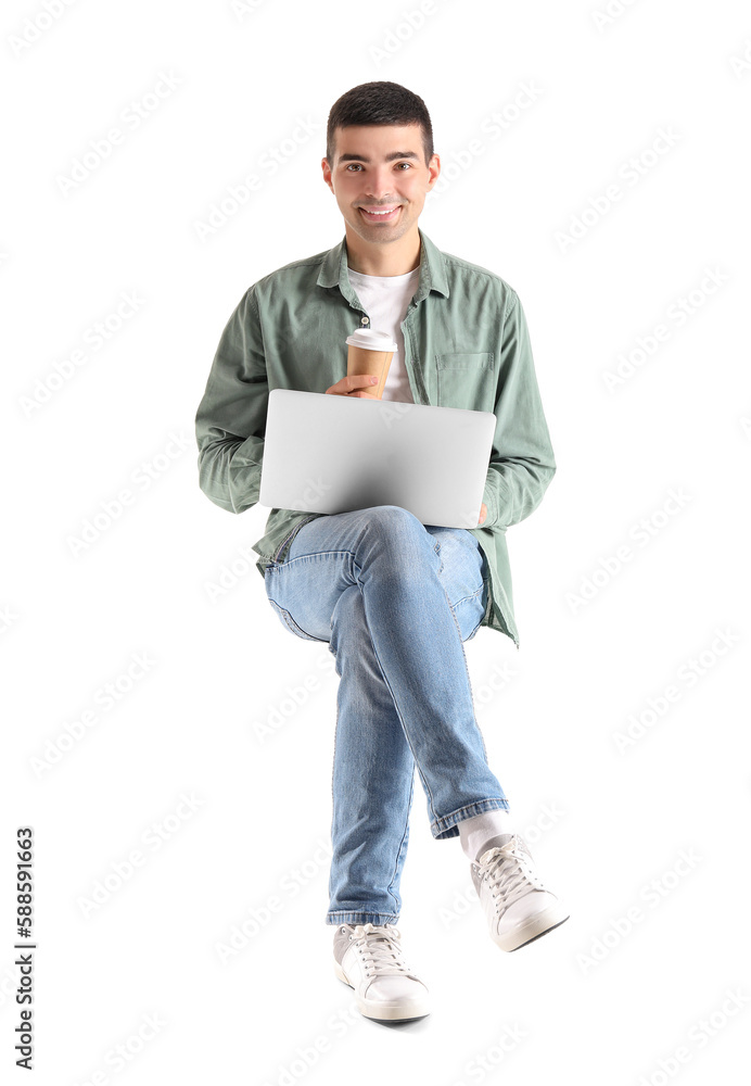 Young guy with cup of coffee using laptop in chair on white background Young guy with cup of coffee using laptop in chair on white background