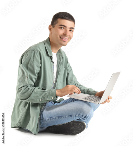 Young guy with laptop sitti...