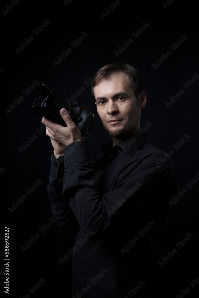 Low key portrait of photographer man with a photo camera in the dark, copy space. Low key portrait of photographer man with a photo camera in the dark, copy space.