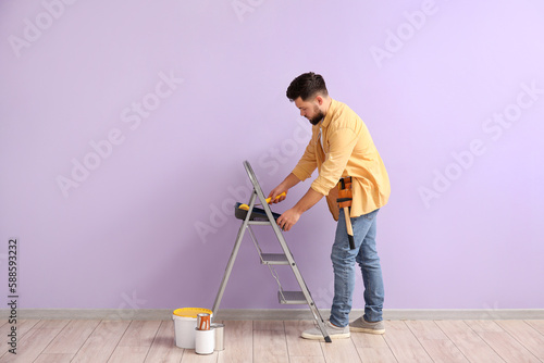 Young man with paint roller...