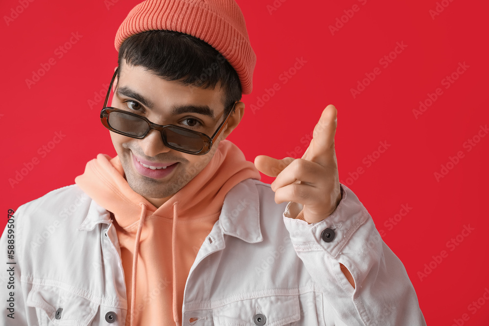 Young man in sunglasses on red background, closeup Young man in sunglasses on red background, closeup