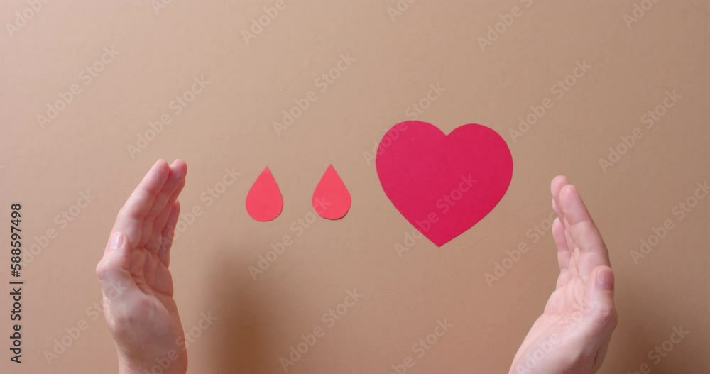 Hands of caucasian man over heart and blood drops on beige background, slow motion Hands of caucasian man over heart and blood drops on beige background, slow motion