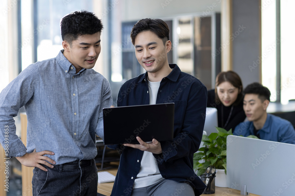 © Blue Jean Images - Chinese business people talking in office