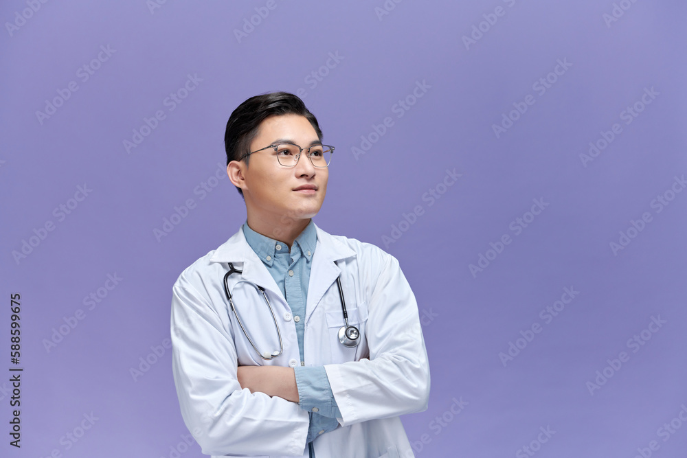 young male doctor in white coat with stethoscope posing with crossed arms young male doctor in white coat with stethoscope posing with crossed arms