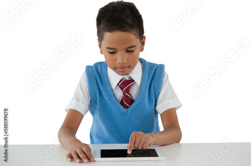 Schoolboy using digital tablet at table