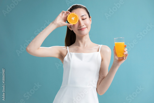 Beautiful young Chinese woman drinking orange juice photo