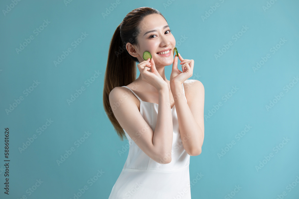 Beautiful young Chinese woman with cucumber slices