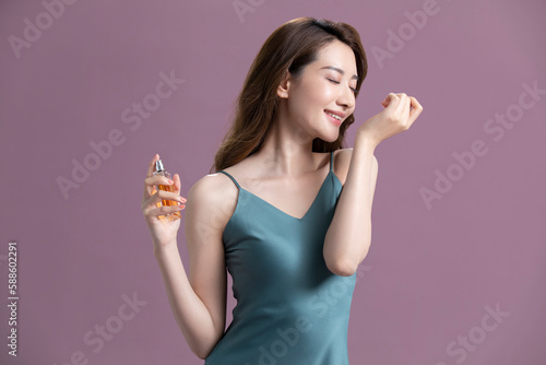 Beautiful young Chinese woman with perfume