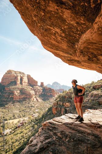 30s female stands on cliff enjoying views of Boynton Canyon in Sedona.