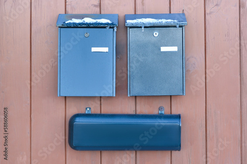 View of metal mailboxes on wooden fence