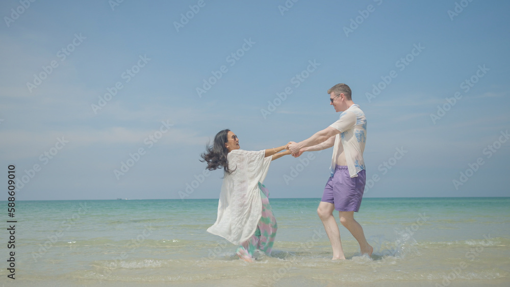 Couples hold hands and walk along the beach on their summer vacation and they smile and have fun on vacation. Couples hold hands and walk along the beach on their summer vacation and they smile and have fun on vacation.