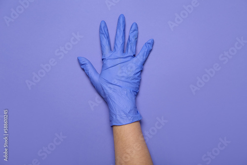 Woman in medical glove on violet background