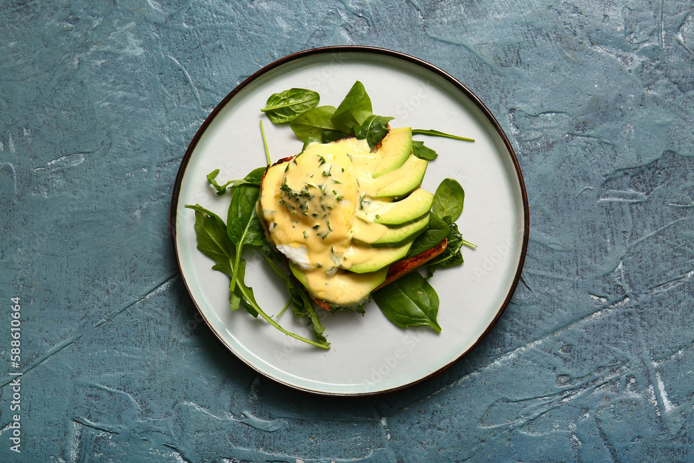 Plate with tasty egg Benedict on grey grunge table Plate with tasty egg Benedict on grey grunge table