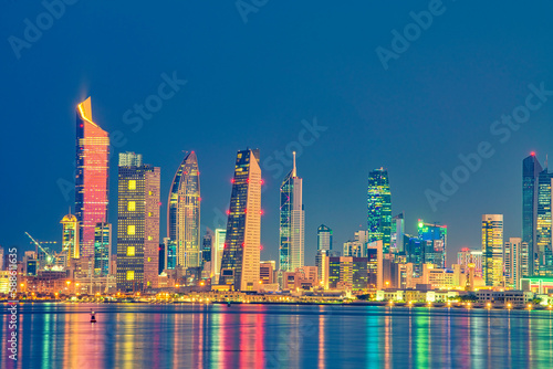 Obraz na płótnie Kuwait Skyline view from beach during the national day celebration. Kuwait National day lights on the building and Kuwait flag lights during the night time. Kuwait City skyline view.... w salonie