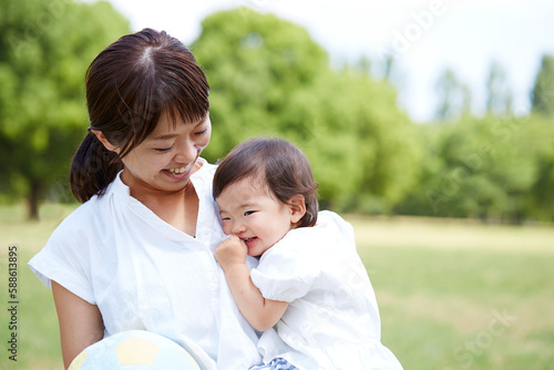 公園で母に抱っこされている赤ちゃん