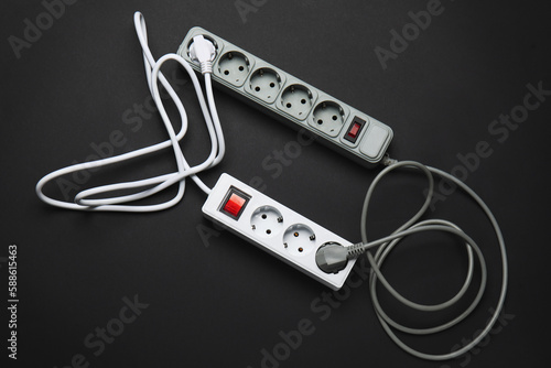 Electric extension cords on black background