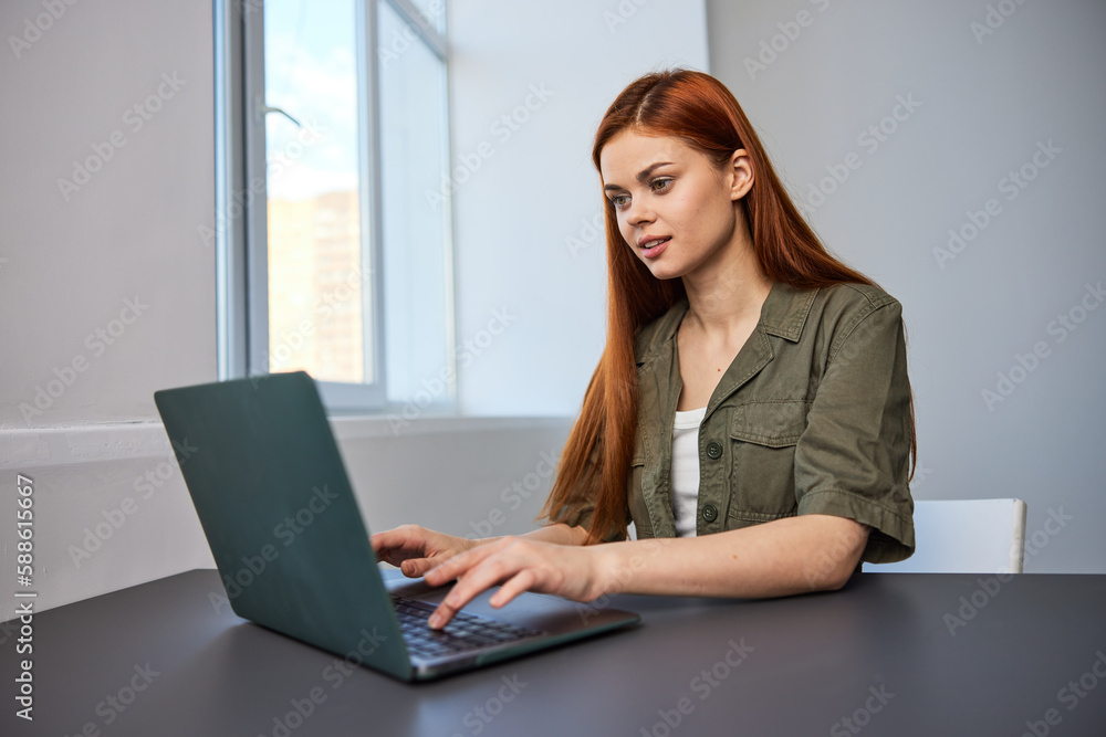 portrait of a happy, joyful woman sitting at a laptop and working in the office portrait of a happy, joyful woman sitting at a laptop and working in the office
