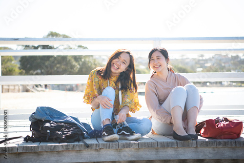 桟橋に座って笑っている女性2人 photo