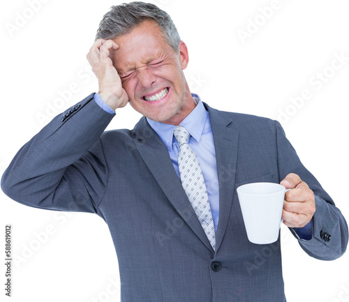 Businessman suffering from headache while holding coffee cup