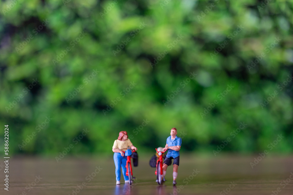 Fototapeta premium Miniature people standing with bike and green background , World bicycle day concept
