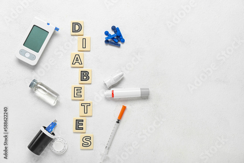 Word DIABETES with medical supplies on white background