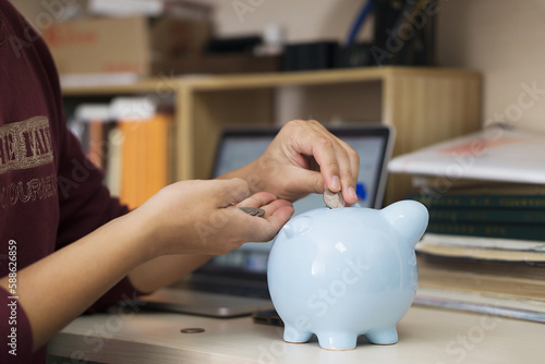 Put coins into a piggy bank to save money