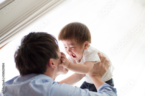 父親にたかいたかいをされる幼児 photo