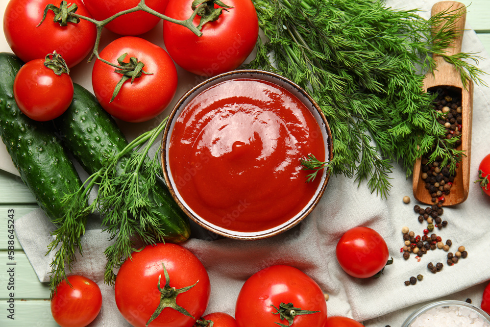 Bowl with tasty ketchup and fresh vegetables on table, closeup