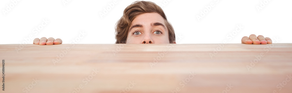 Man hiding behind desk against white background Man hiding behind desk against white background