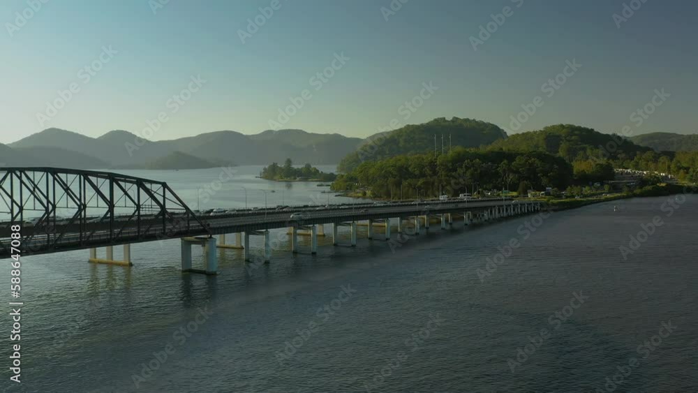 Moving aerial side view of the busy traffic on two seperate bridges in the afternoon sunshine. Moving aerial side view of the busy traffic on two seperate bridges in the afternoon sunshine.