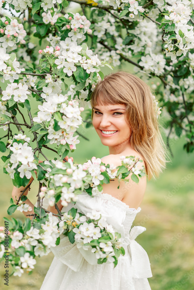 Happy beautiful smiling young woman in flowering spring garden Happy beautiful smiling young woman in flowering spring garden