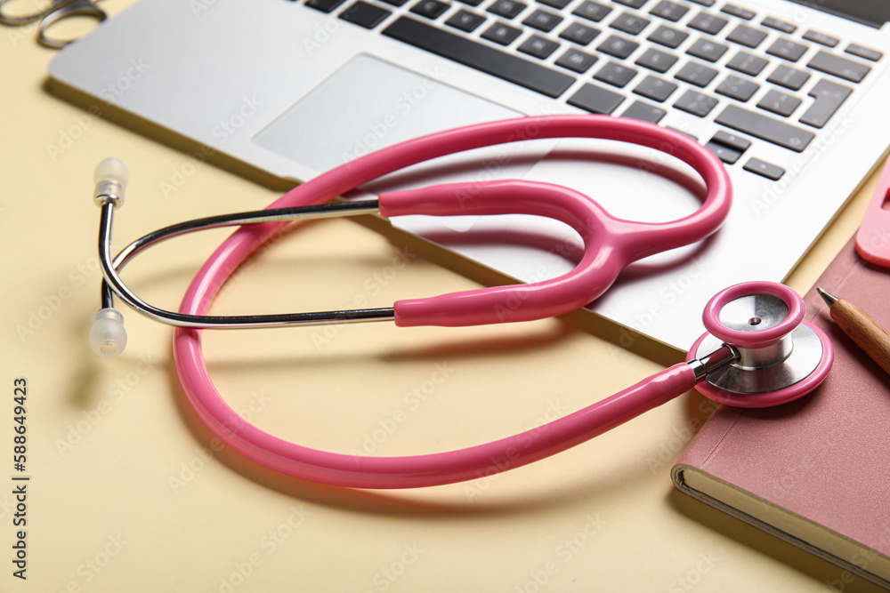 Stethoscope and laptop on yellow background, closeup Stethoscope and laptop on yellow background, closeup