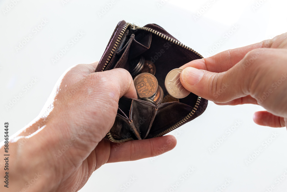 Obraz premium 革製の小銭入れから小銭を取り出す