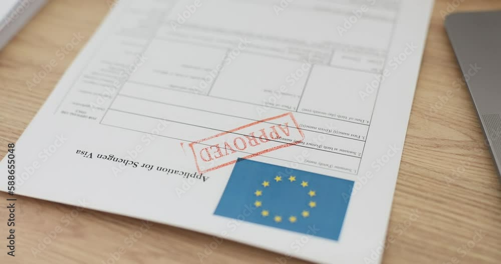 Hand of inspector putting stamp approved on schengen visa application closeup. Permission to travel abroad concept Hand of inspector putting stamp approved on schengen visa application closeup. Permission to travel abroad concept
