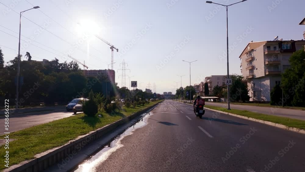 Delivery motorbike drive fast on city avenue at sunset Delivery motorbike drive fast on city avenue at sunset