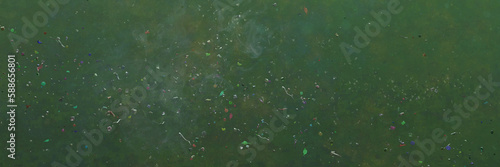 plastic pollution, microplastic particles in ocean water, banner format photo