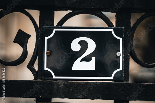 Eine Zahl, Zwei mit weißer Schrift auf einem blauen Metallschild mit schrauben 