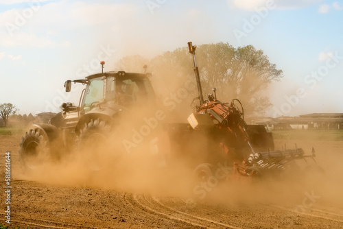 фотографія Tractor agriculture work field plow plowing land dust cloud drought climate chan