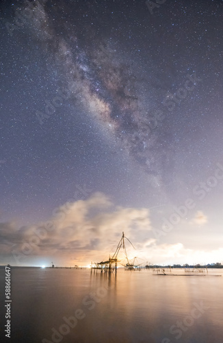 The vertical of Milky Way with a wood of fish hunt on Thailand