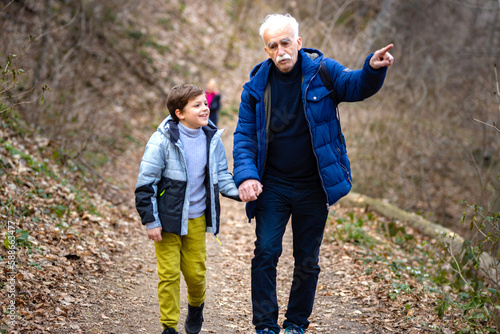 Grandpa showing his grandson the nature in the woods