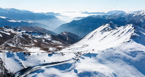 Aerial view of the beautiful scenery of the top of Jiajin Mountain in Sichuan China. The snow-covered peaks and the winding road meander up the hillside, and the clouds and mist fill the valley in th photo