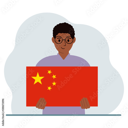 A man holds a Chinese flag. The concept of demonstration, national holiday or patriotism. Nationality.
