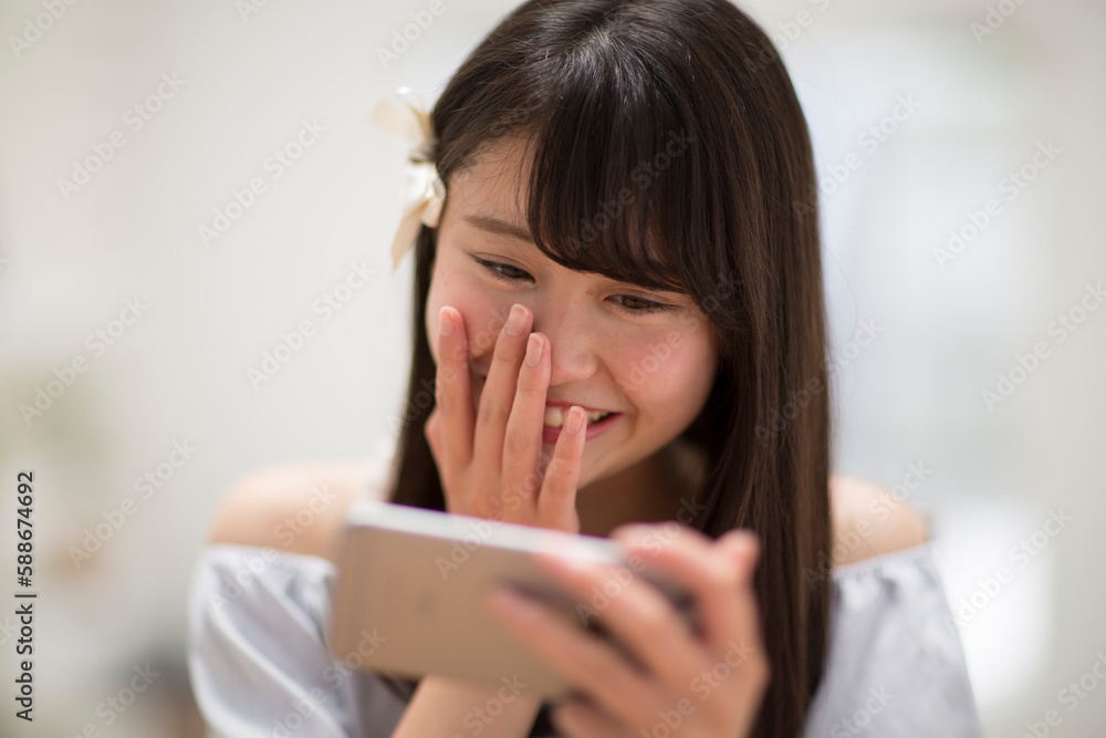 スマートフォンを見て笑う女性 スマートフォンを見て笑う女性