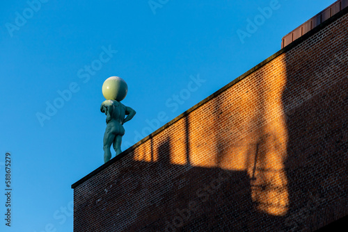Photography Copenhagen, Denmark An Atlas sculptur eon top of a building in the old Carlberg brewery area