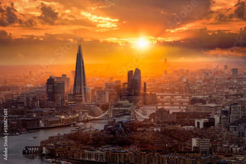 A beautiful sunset behind the London skyline with Tower Bridge, River Thames and the corporate skyscrapers © moofushi